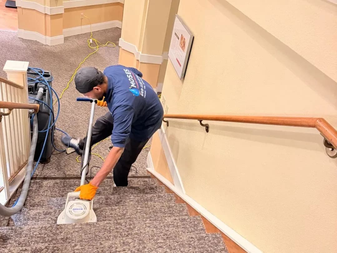 Technician cleaning carpeted stairs by hand